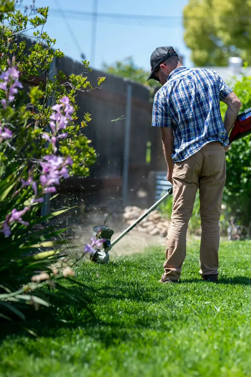 A landscaper mowing a lawn, the kind of tidy, consistent work that helps a landscaping business win more clients