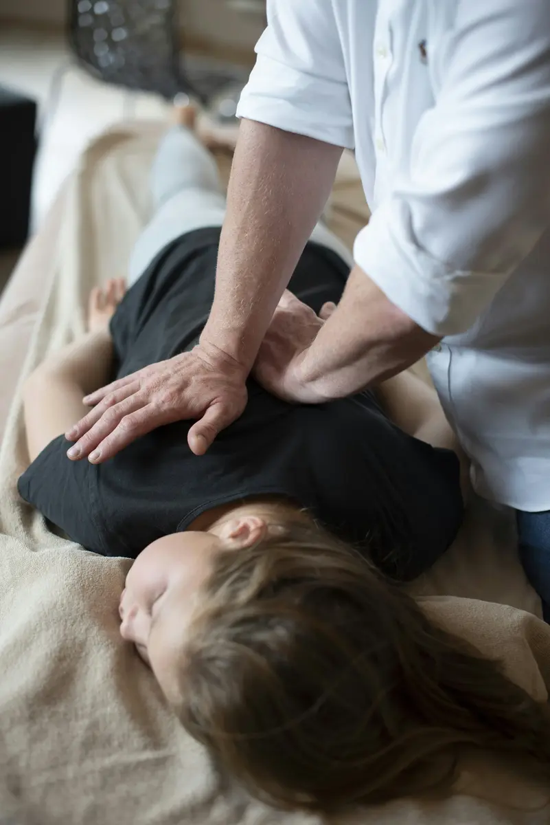 Chiropractor treating a patient's back during a consultation