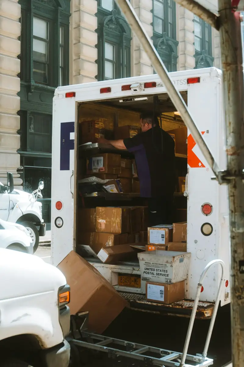 A mover loading boxes into the back of a moving truck, the kind of organised work that helps a moving company win more clients