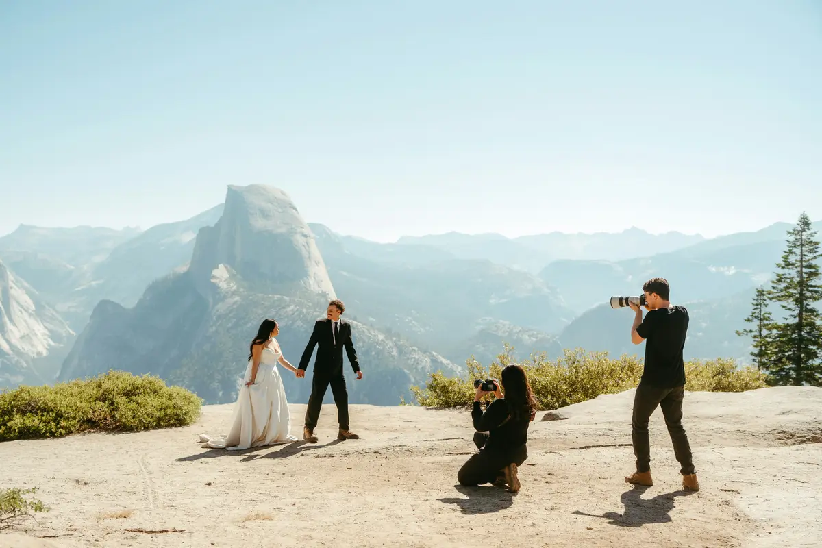 A photographer capturing a couple with a mountain backdrop, the kind of session that leads to a repeat booking